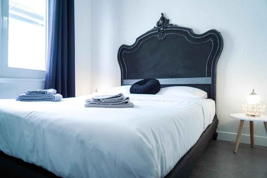 沙托鲁Le Dolce Vita - Proche Gare - Spacieux的一张带黑色床头板和毛巾的床