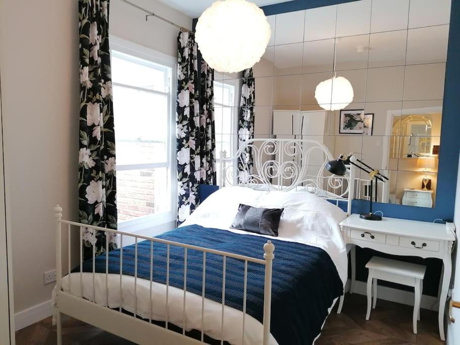 贝尔法斯特Stunning 3 Bedroom townhouse in the heart of city的一间卧室配有一张床、一张书桌和一个窗户。