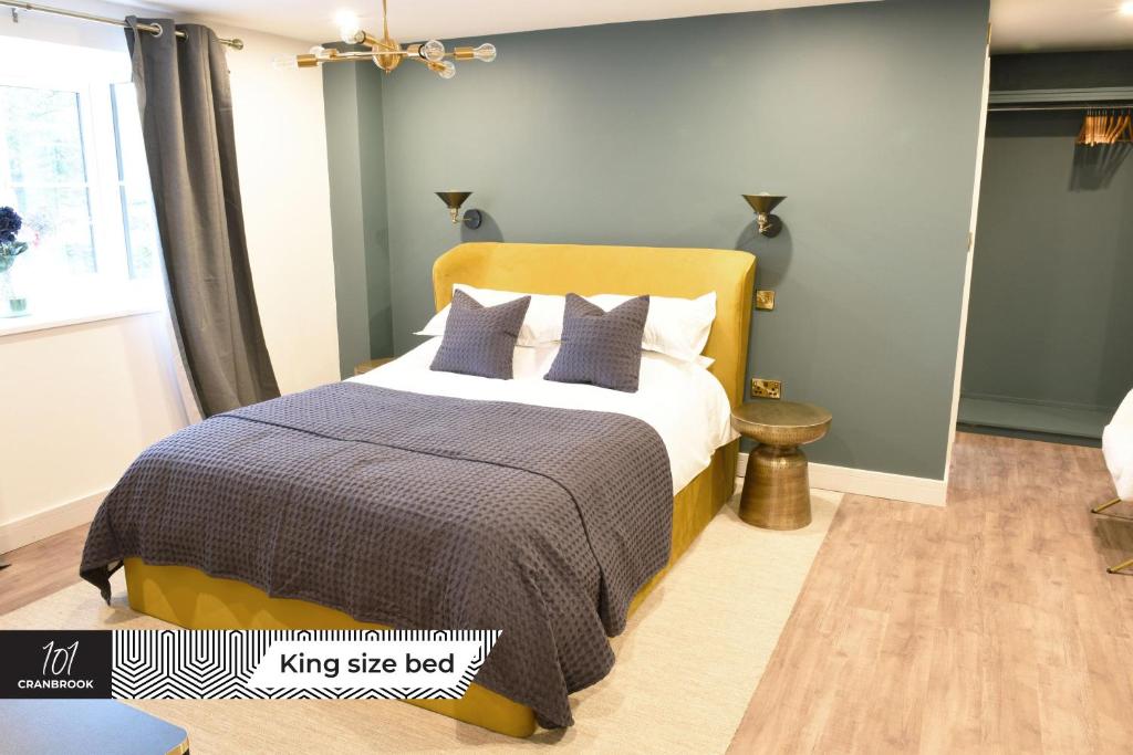 米尔顿凯恩斯Newly Refurbished Luxury Hotel Style Accommodation的一间卧室配有一张特大号床和蓝色的墙壁