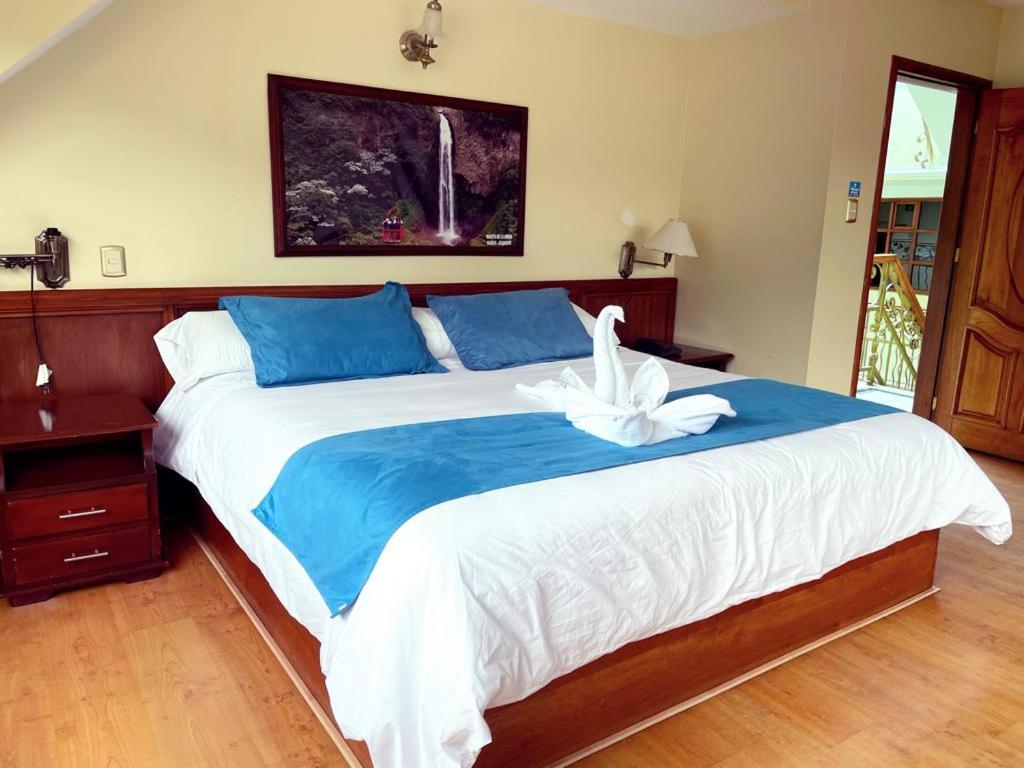 巴尼奥斯东德马赛洛酒店的一间卧室配有一张大床,上面有白色鸟
