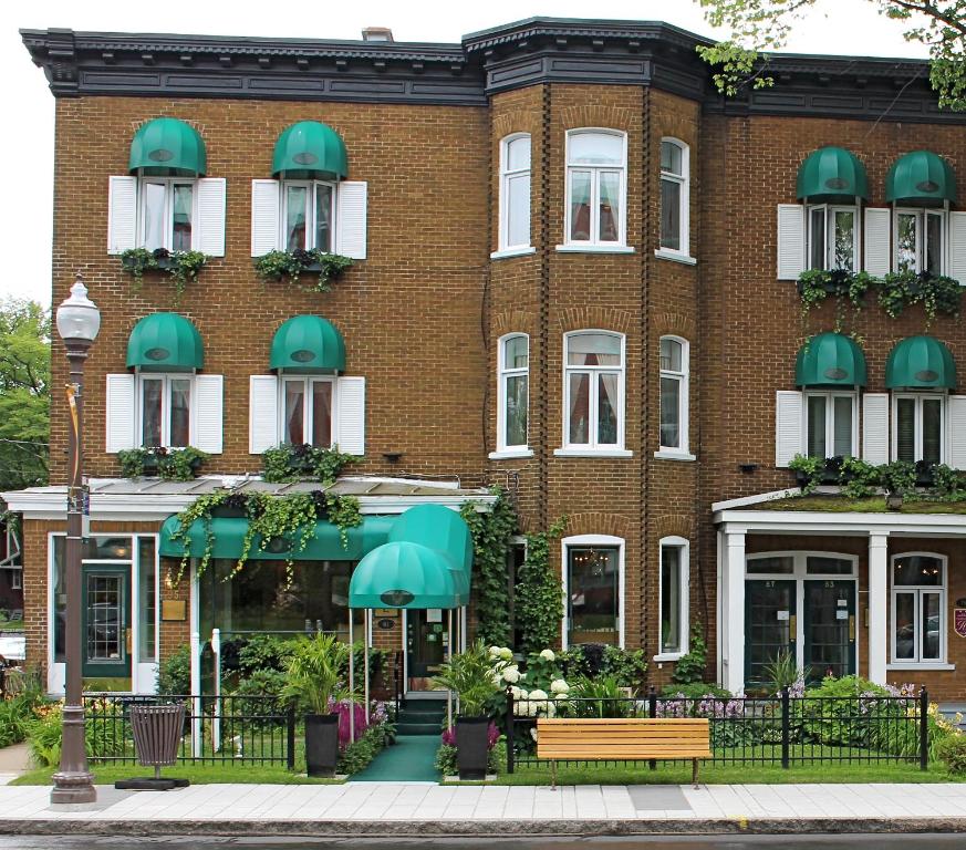 魁北克市瑞拉查尔斯- 亚历山大酒店的一座带绿色遮阳篷的大型砖砌建筑