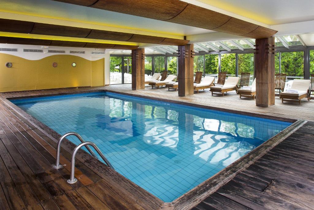 塞尔河畔维克家庭之家酒店的一座配有桌椅的酒店游泳池