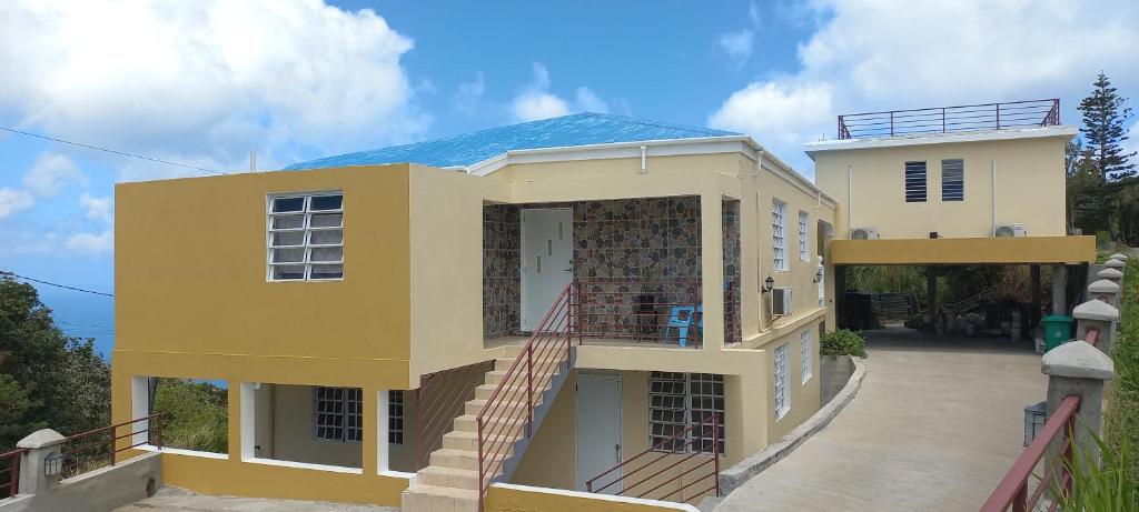 Tortola IslandMore Than Beauty Properties的黄色的房子,前面有楼梯