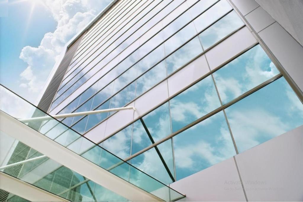 吉隆坡Xpeed Holiday Hotel的建筑的玻璃幕墙,背景是天空