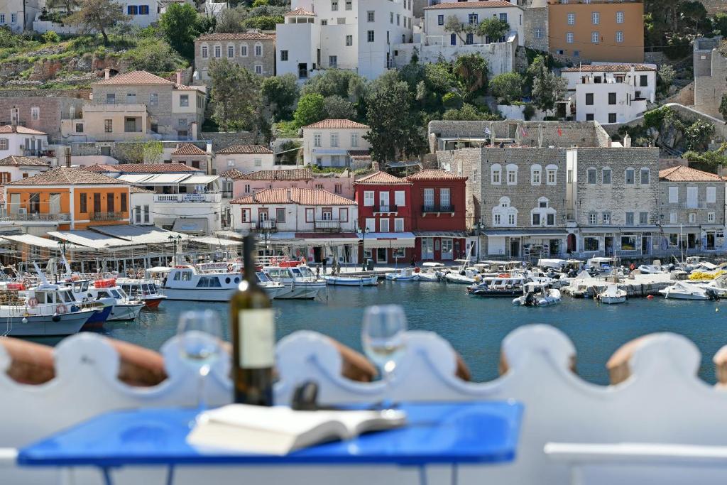 伊兹拉Delfini Hotel的海港桌子上坐着一瓶葡萄酒