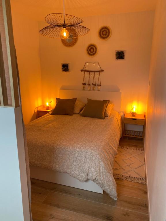 Le TourneurEscapade Normande avec son sauna privé的一间卧室配有一张带两个灯的床