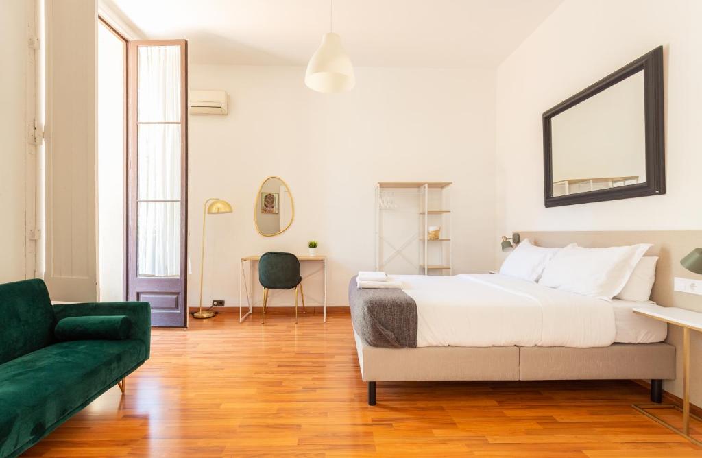 巴塞罗那Casa Lolita的白色卧室配有床和绿色沙发