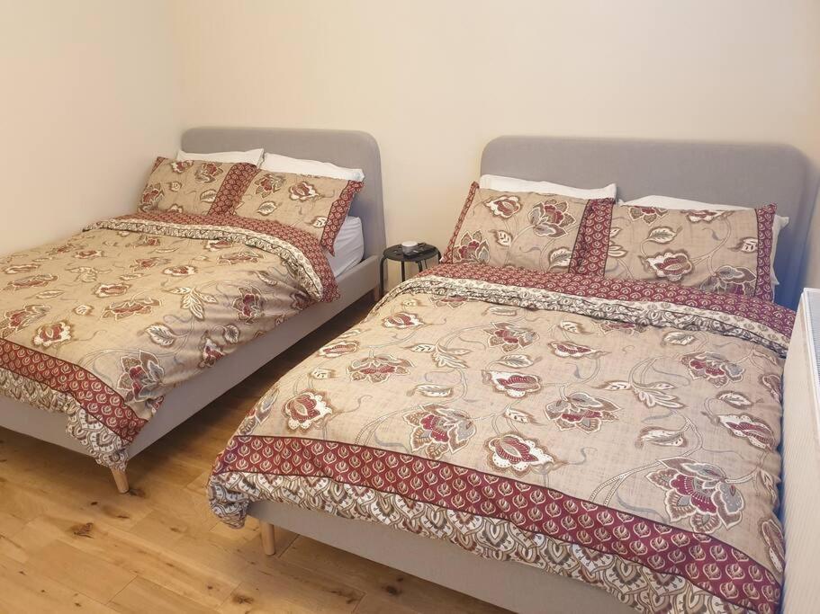 East BarnetLondon Luxury 2 Bedroom Flat Sleeps 8 free parking的卧室内两张并排的床