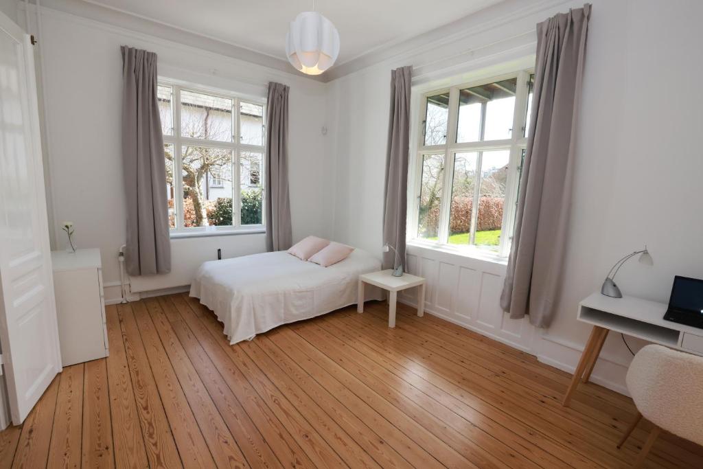 夏洛滕隆Scandi-Hygge Seaside House - only 10mins to Copenhagen的一间白色卧室,配有床和2个窗户