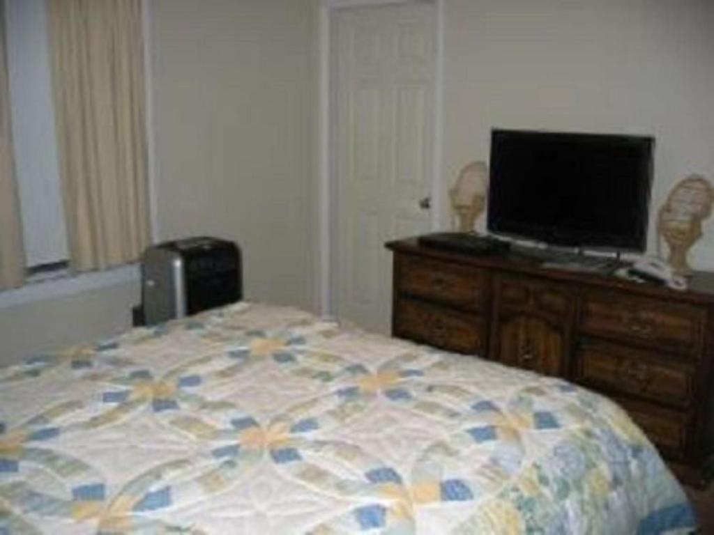 PanacaPine Tree Inn的一间卧室配有一张床,梳妆台上配有电视