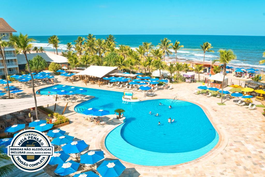 萨尔瓦多Gran Hotel Stella Maris Urban Resort & Conventions的享有带游泳池和海洋的度假村的空中景致