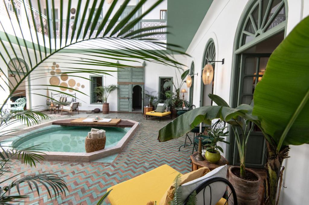 马拉喀什Riad Agathe & Spa的一个带游泳池和植物的室内庭院
