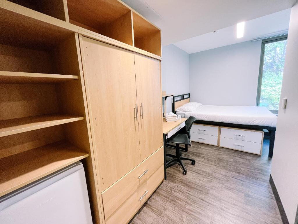 金斯顿Queen's University Residence的一间卧室配有书桌,卧室内配有一张床
