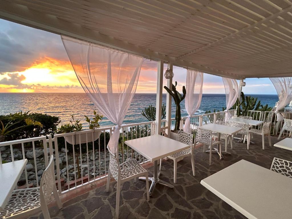 特罗佩阿Mediterranean Boutique Hotel的日落时分海景餐厅