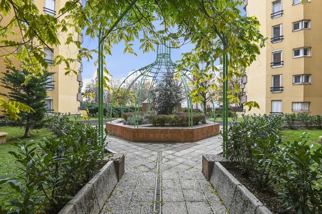 阿涅勒"Joie de vivre" - Parisian Spacious & Charming flat的一座花园,在一座建筑的中间有一个喷泉