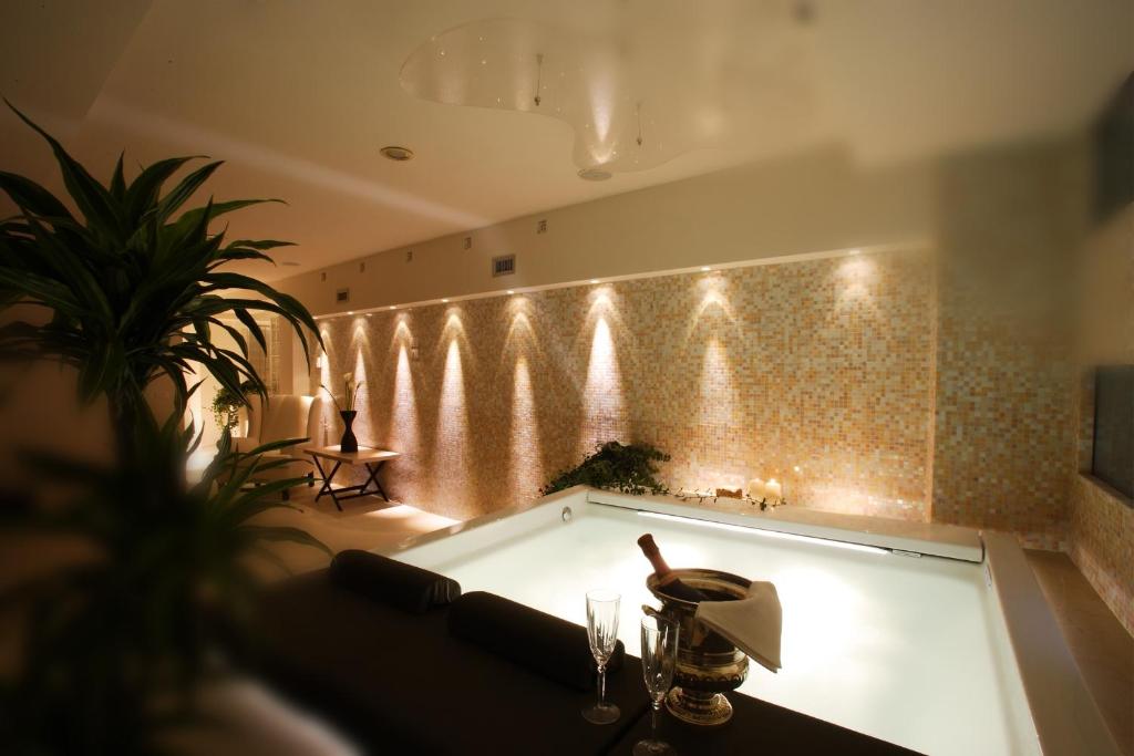 佛罗伦萨朋特维奇欧套房温泉酒店的浴缸位于带灯光的墙壁内