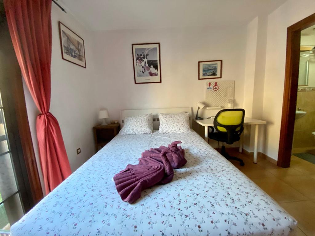 厄尔梅达诺Bedroom Medanomar 1的一间卧室配有一张床、一张桌子和一把椅子