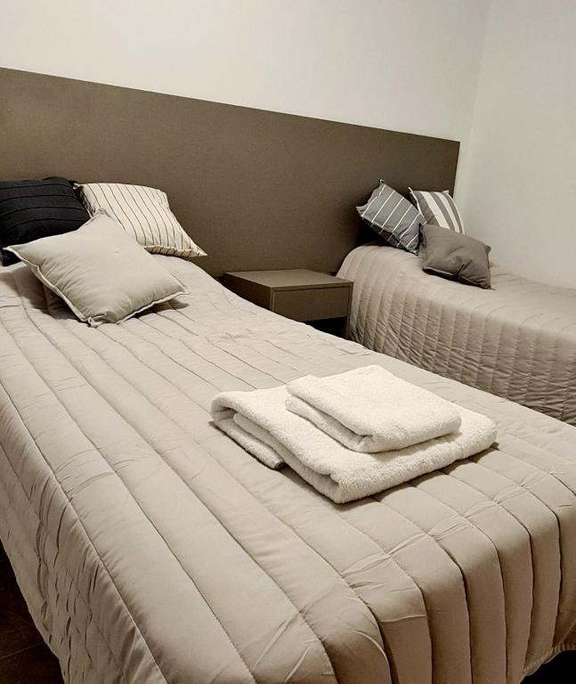 奇莱西托Tres Marías Apart的一间卧室配有两张带毛巾的床