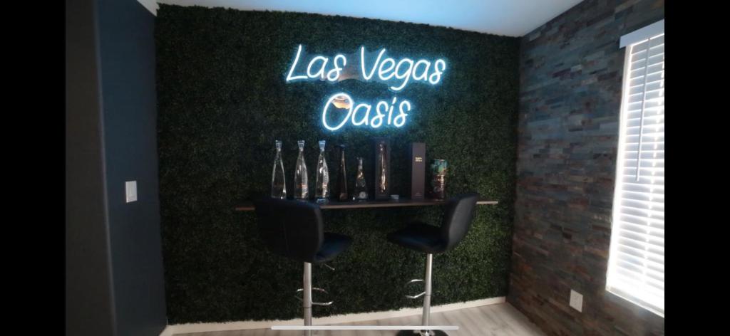 拉斯维加斯Las Vegas Oasis的酒吧,墙上有两把椅子和 ⁇ 虹灯标志