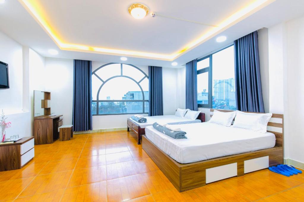 Dĩ AnHoa Cúc Phương Hotel Dĩ An - Bình Dương的一间卧室设有两张床和大窗户