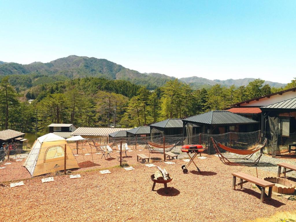Shimojo muraOogute Kohan Shirasagi So的露营区设有帐篷、野餐桌和长椅