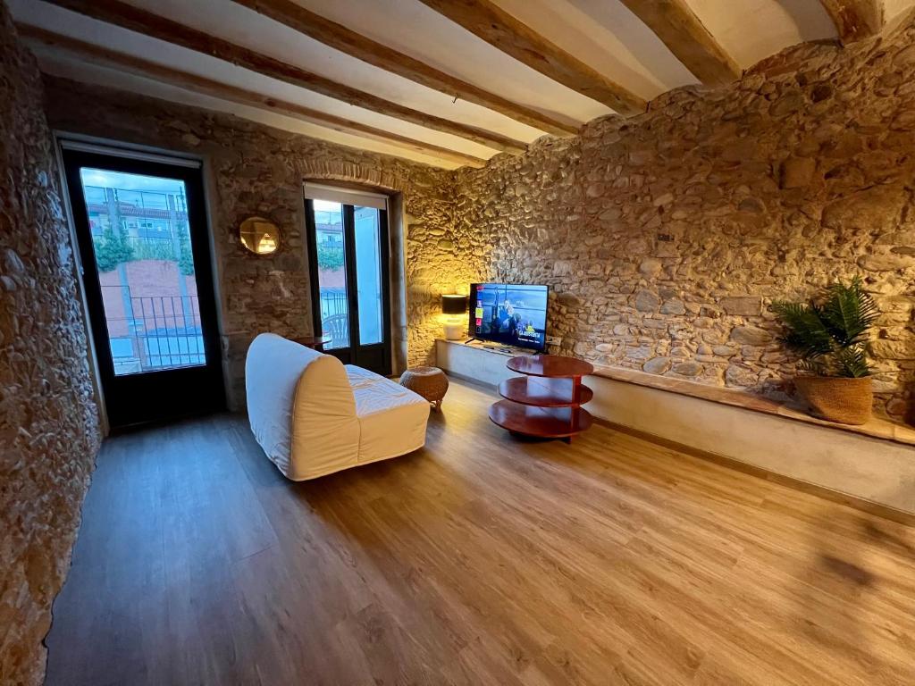 赫罗纳Precioso Girona largas estancias的客厅配有白色沙发和石墙