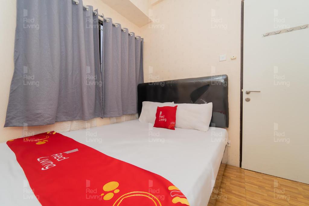 万隆RedLiving Apartemen Tamansari Panoramic - Rasya Room with Netflix的一间卧室配有一张床铺,床上铺有红色毯子