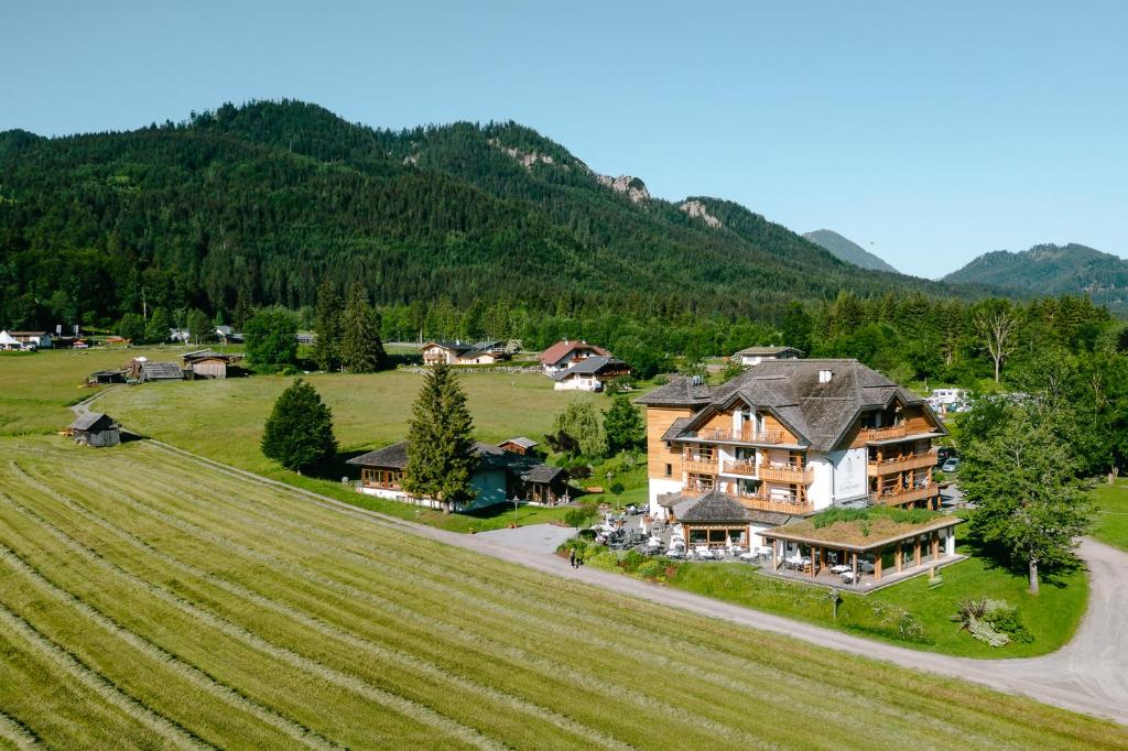 魏森湖Das Leonhard - Naturparkhotel am Weissensee的田野上大房子的空中景观