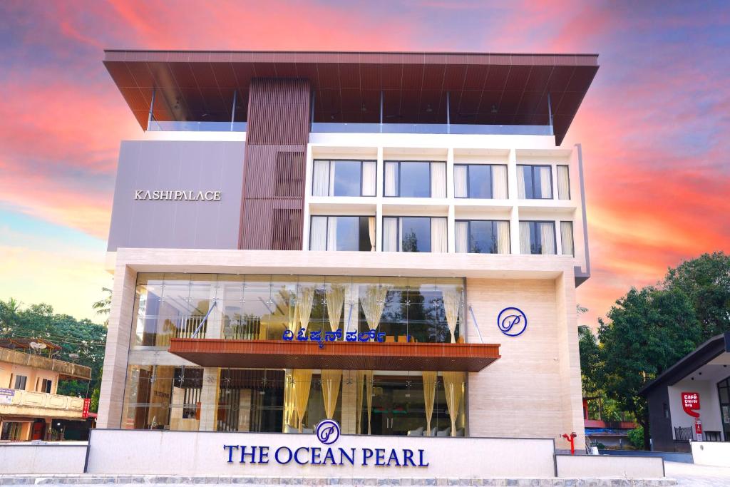 DharmastalaThe Ocean Pearl Dharmasthala Ujire的日落时分有海洋珍珠的建筑