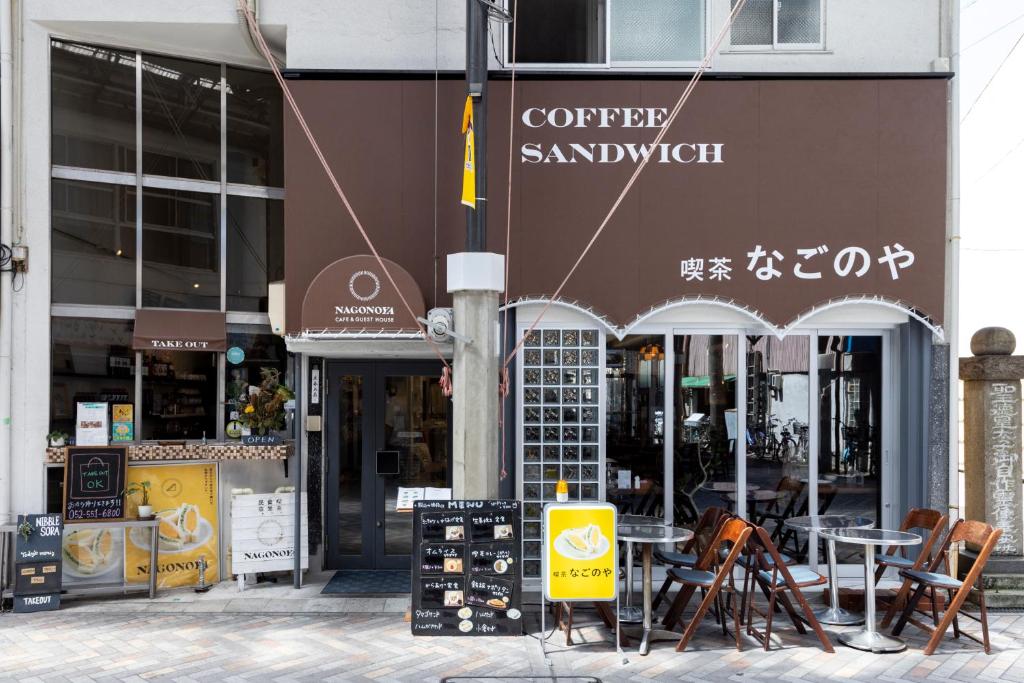 名古屋吃茶食堂旅舍的大楼前的咖啡馆,配有桌椅