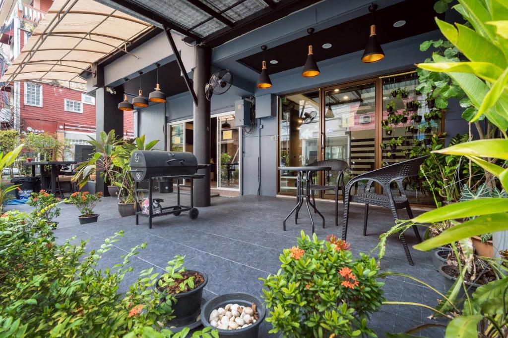 芭东海滩Black Pantera Hostel的一个带桌椅和植物的庭院