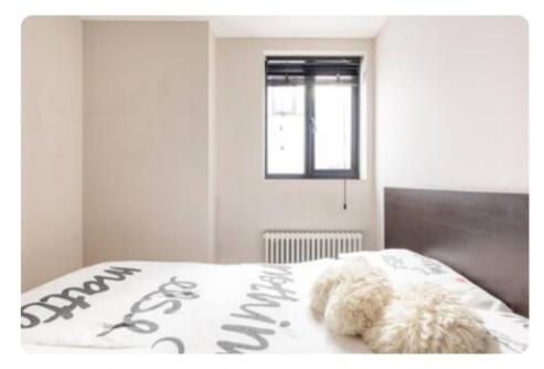 伦敦Bitcoin Adorabile suite nel cuore del magnifico Chiswick的一只泰迪熊躺在卧室的床上