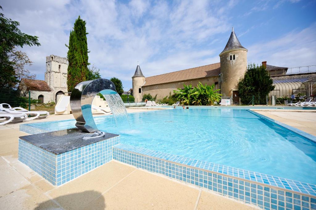 IngrandesGlamping Loire Valley的一座大楼前的游泳池,带喷泉