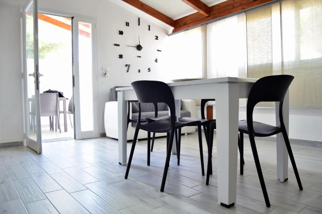 切萨雷奥港Amare Home的餐桌、椅子和墙上的时钟