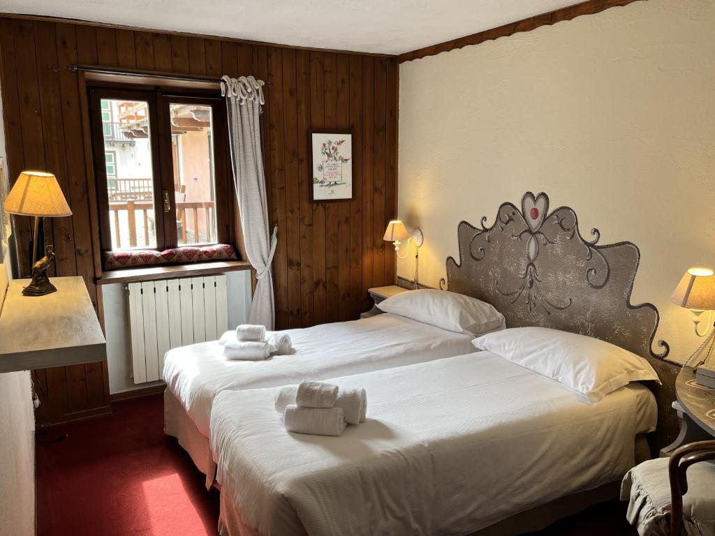 克拉维埃Hotel Ristorante Il Principe的一间卧室配有两张带毛巾的床
