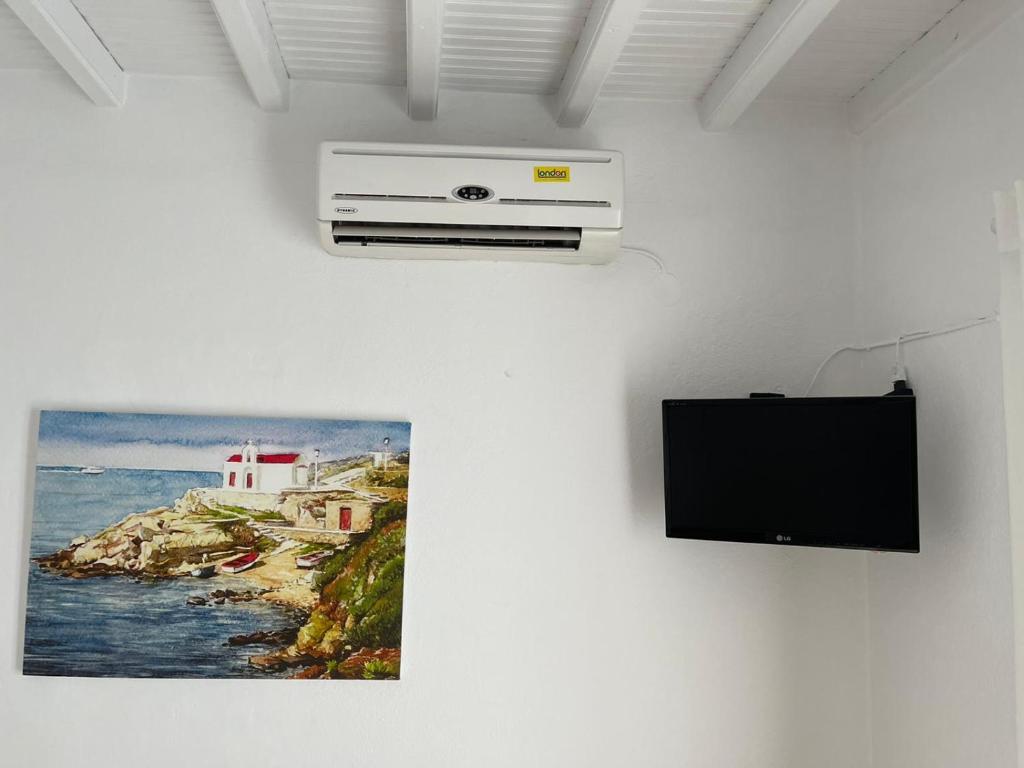 Megali AmmosAnna的墙上挂着电视和照片的墙