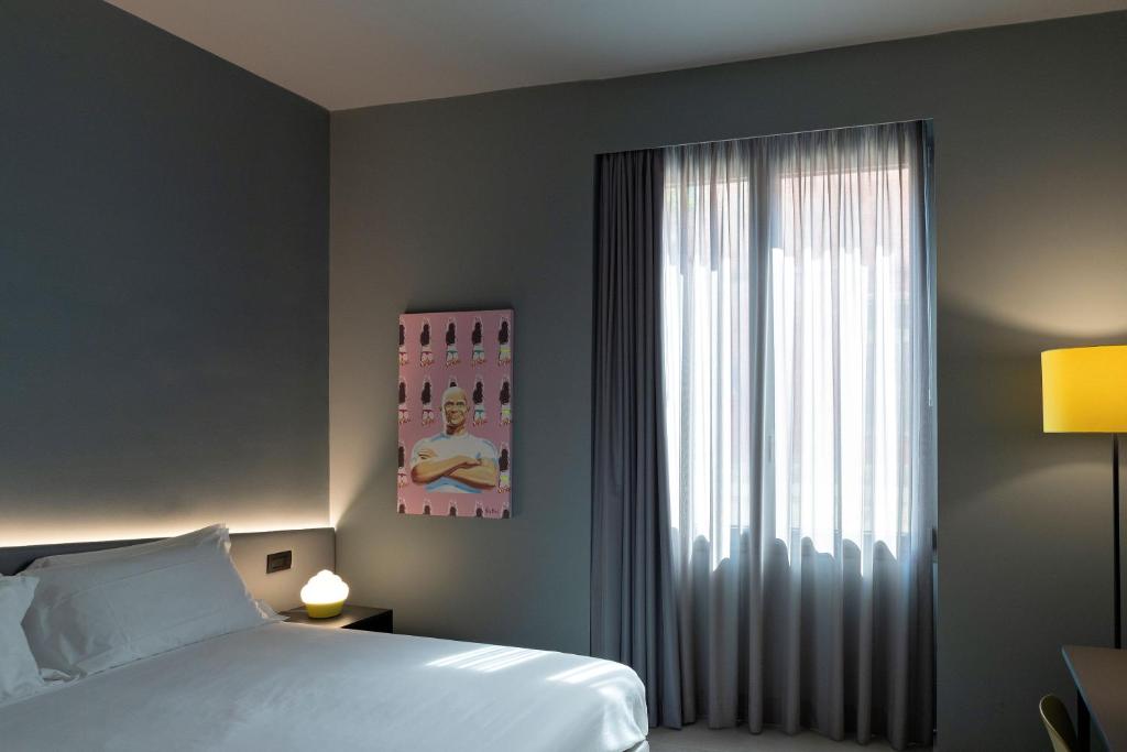 莱切Arryvo Hotel的一间卧室设有一张床和一个大窗户