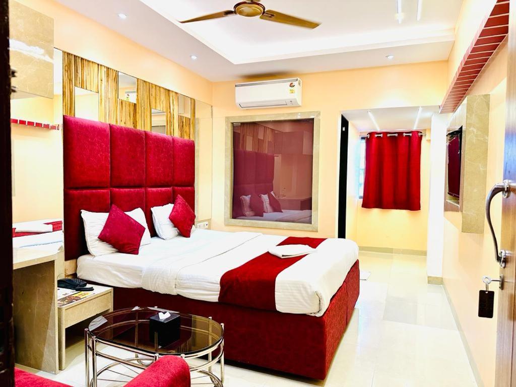 纳威孟买Hotel Vashi Inn的一间卧室配有一张大床和红色床头板