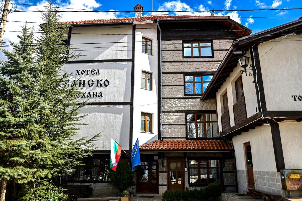索非亚Family Hotel Bansko Sofia的前面有两面旗帜的建筑