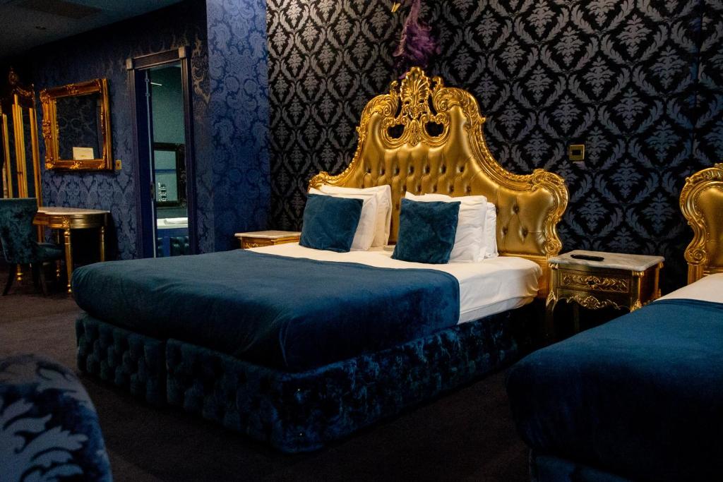 利物浦The Dixie Dean Hotel的一间卧室配有一张大床和金色床头板