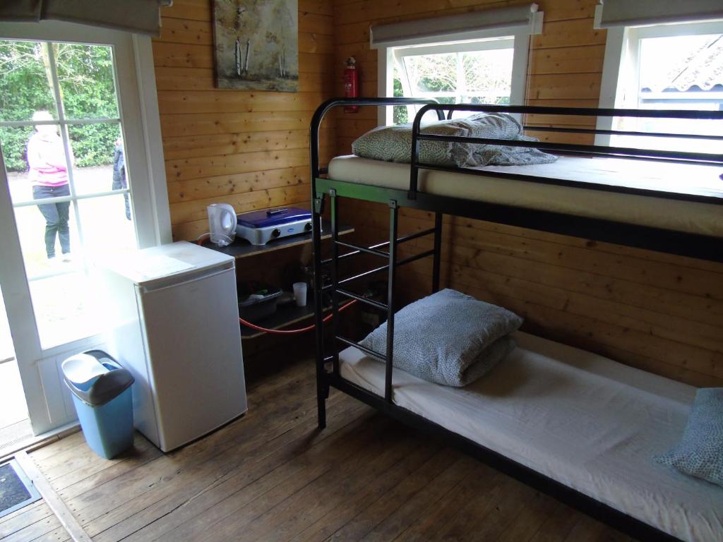 Ter AarCamping de Oude Rijn的小屋内带两张双层床的客房