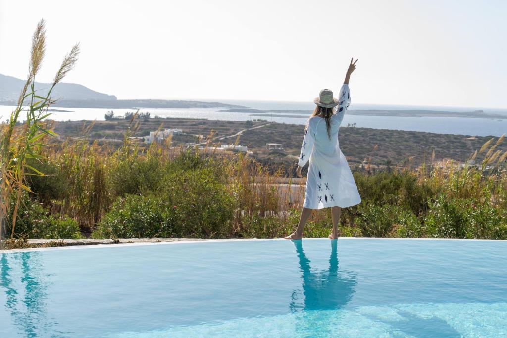 阿吉亚艾里尼帕罗Anthemion Paros - Villas & Suites的女人站在游泳池边