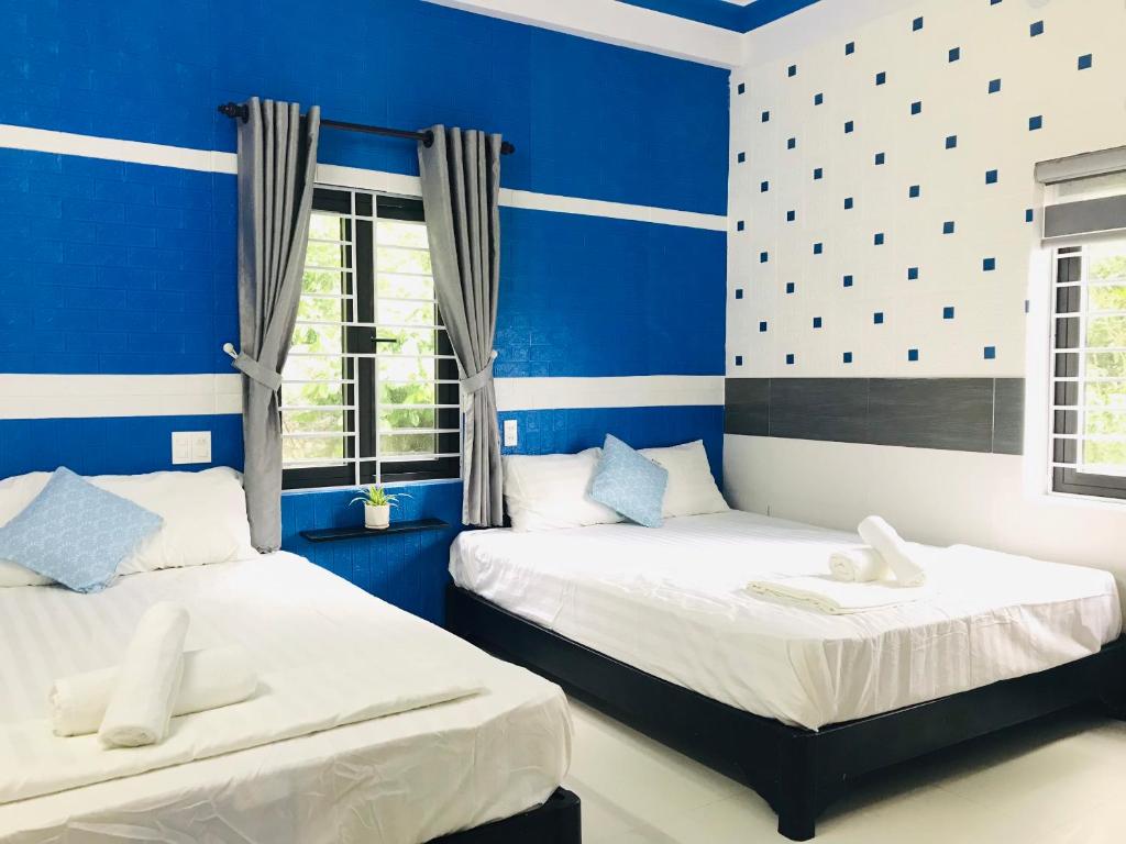 Tân HiệpMonkeyland Cham island Homestay的配有两张床铺的蓝色墙壁和窗户