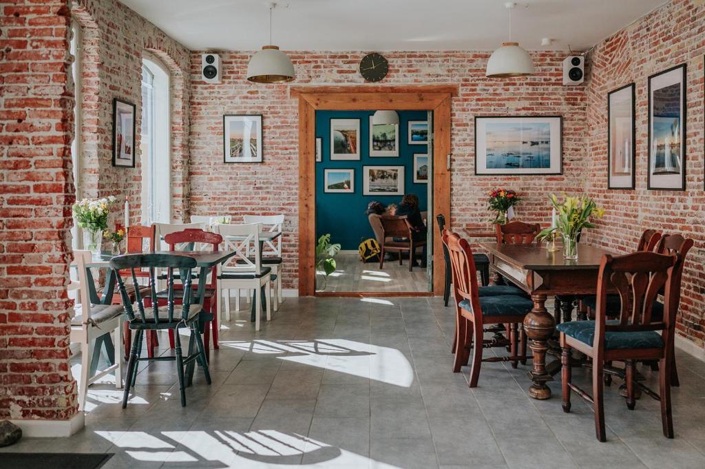 艾勒斯克宾KEFS Guesthouse & Café的一间设有砖墙和桌椅的用餐室