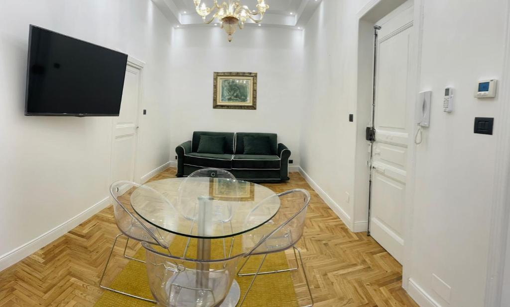 罗马Central Suite的客厅配有玻璃桌和椅子
