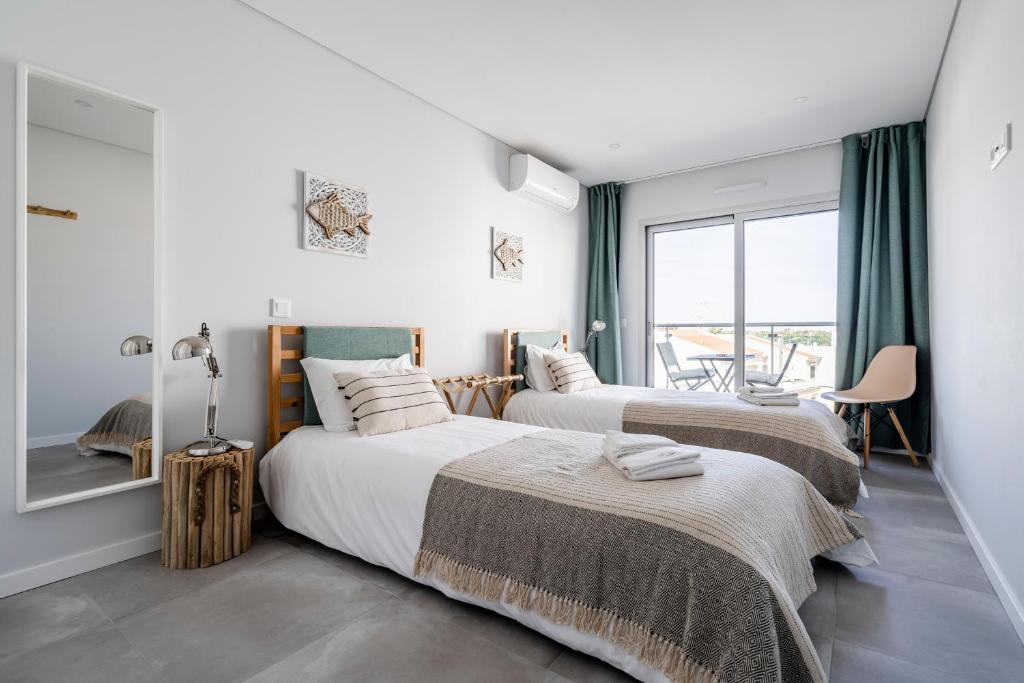 蒙蒂戈杜Coastal Holiday´s Apartment的带窗户的客房内的两张床