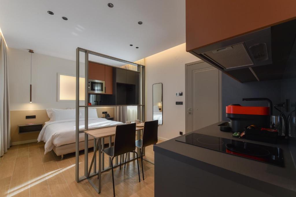 约阿尼纳Zalo Urban Living Spaces的一间卧室配有一张床,厨房配有桌子