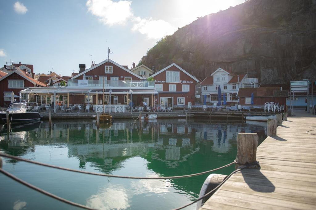 弗加尔巴卡Bryggan Fjällbacka的房屋旁边的水面上设有船只的码头