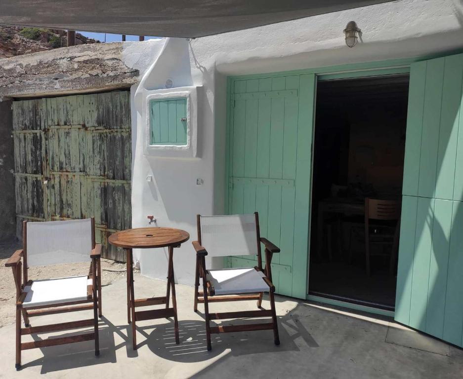 基莫洛斯岛Apanemo Beach House Agios Nikolaos Kimolos的庭院里设有两把椅子和一张桌子