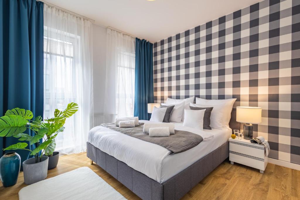 弗罗茨瓦夫Apartment Dąbrowskiego by The Railway Station Wroclaw的一间卧室配有一张带蓝色窗帘的大床